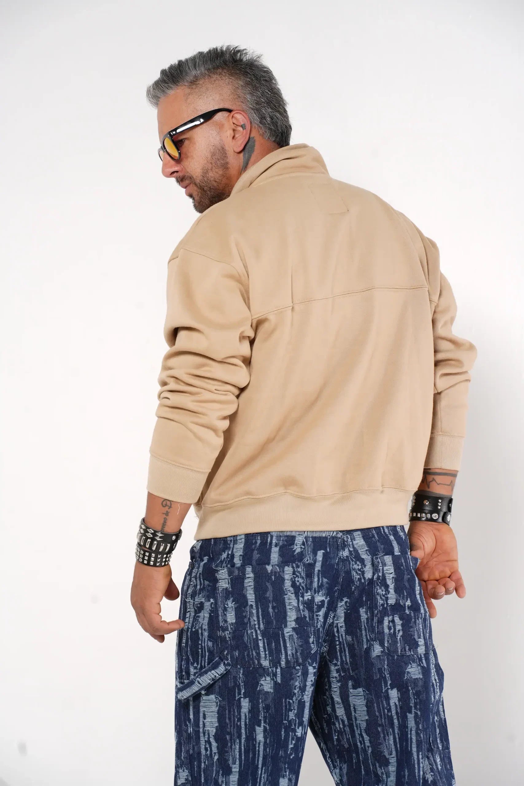 Buzo tipo sudadera beige con cuello alto y broches metálicos