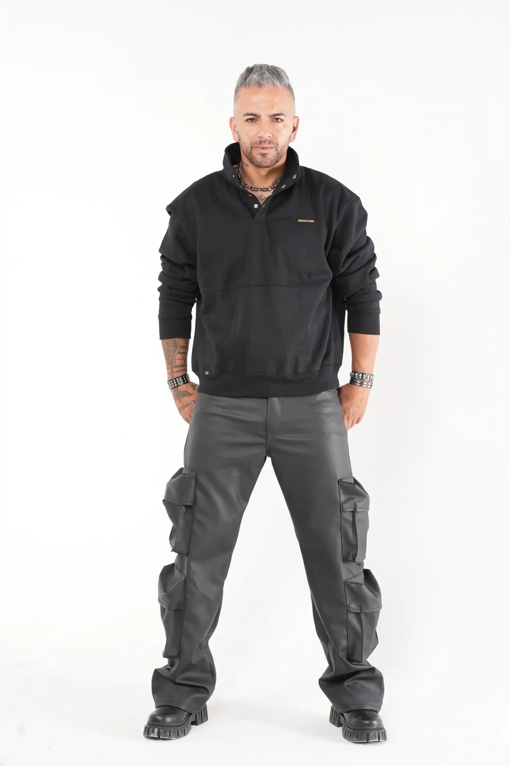 Buzo tipo sudadera negra con cuello alto y broches metálicos