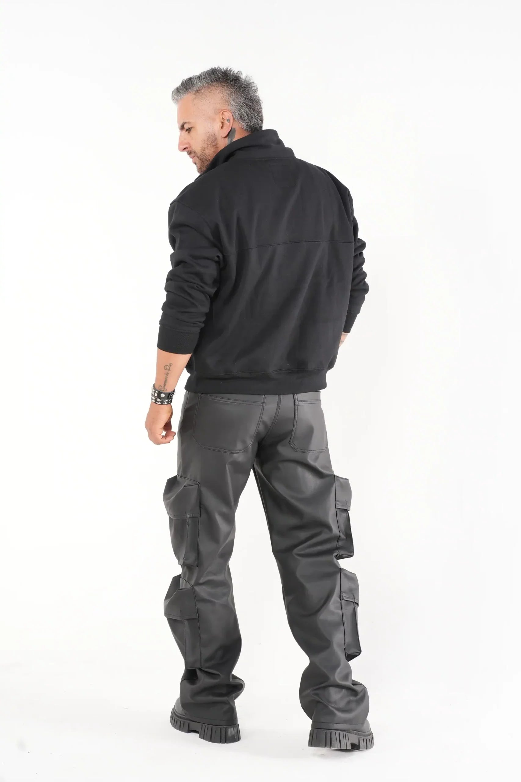 Buzo tipo sudadera negra con cuello alto y broches metálicos