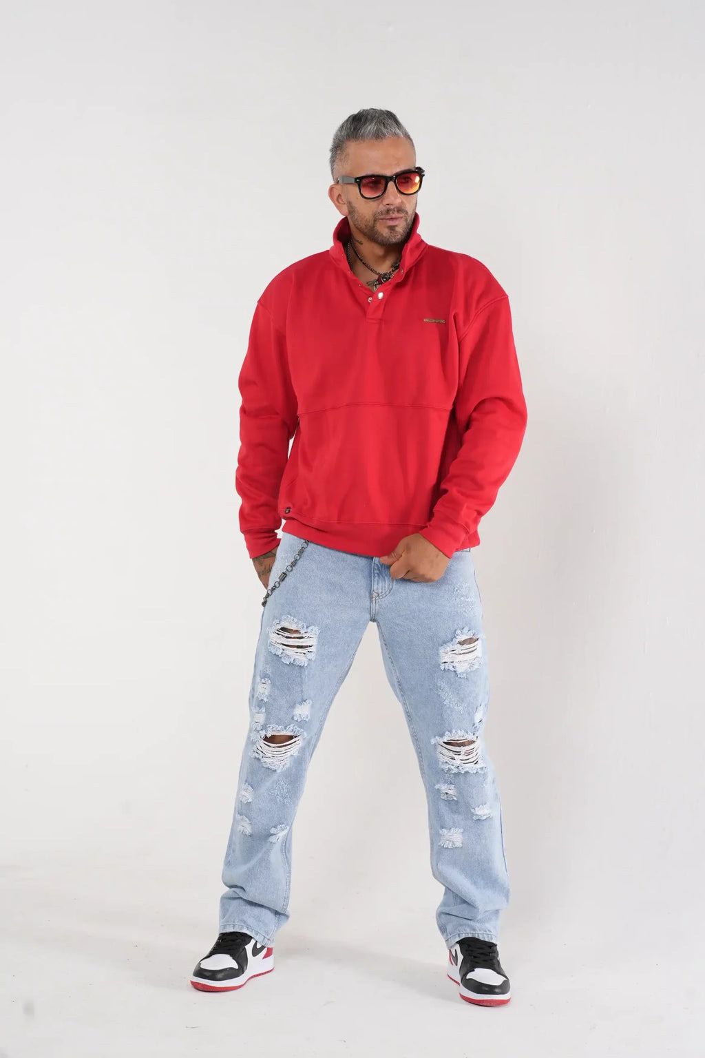 Buzo tipo sudadera rojo con cuello alto y broches metálicos