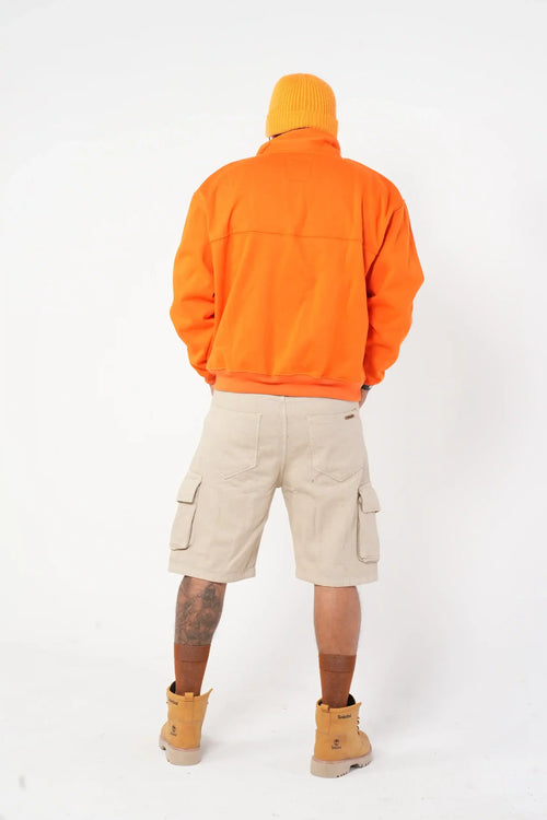 Buzo tipo sudadera naranja con cuello alto y broches metálicos
